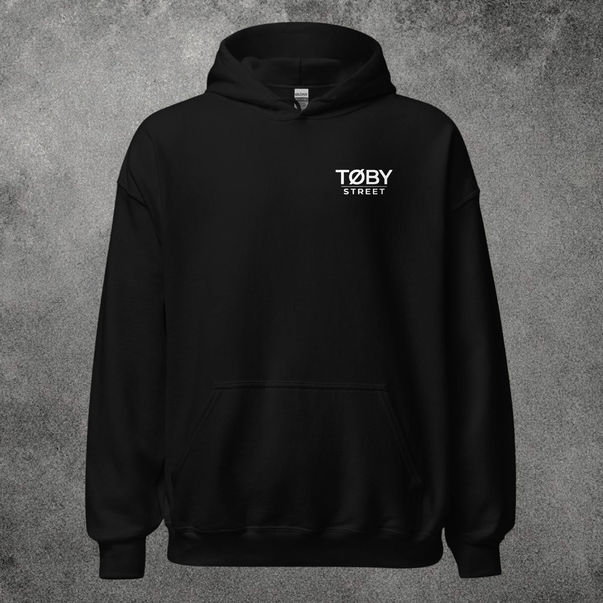 Sudadera con capucha unisex negra TØBY STREET con bolsillo canguro y logo blanco en el pecho sobre fondo gris